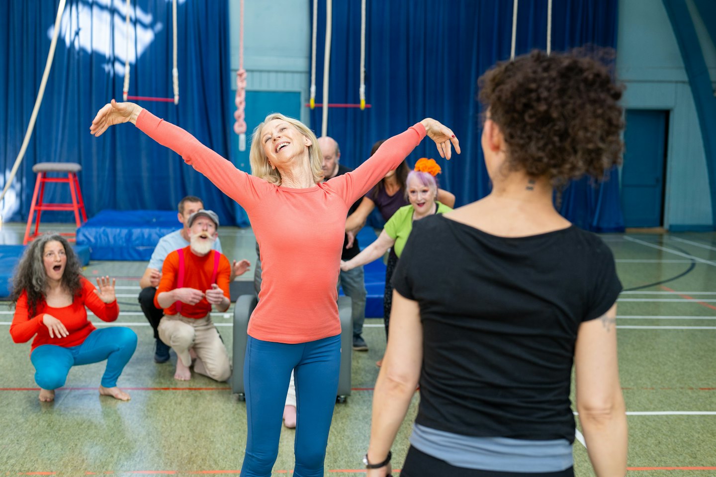 Diverse adults enjoy an energetic indoor fitness class together.