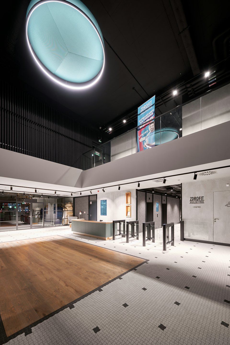 Modern fitness center reception with turnstiles and ZDROFIT branding.